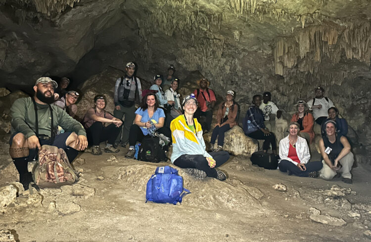 group of teachers sitting in a cave